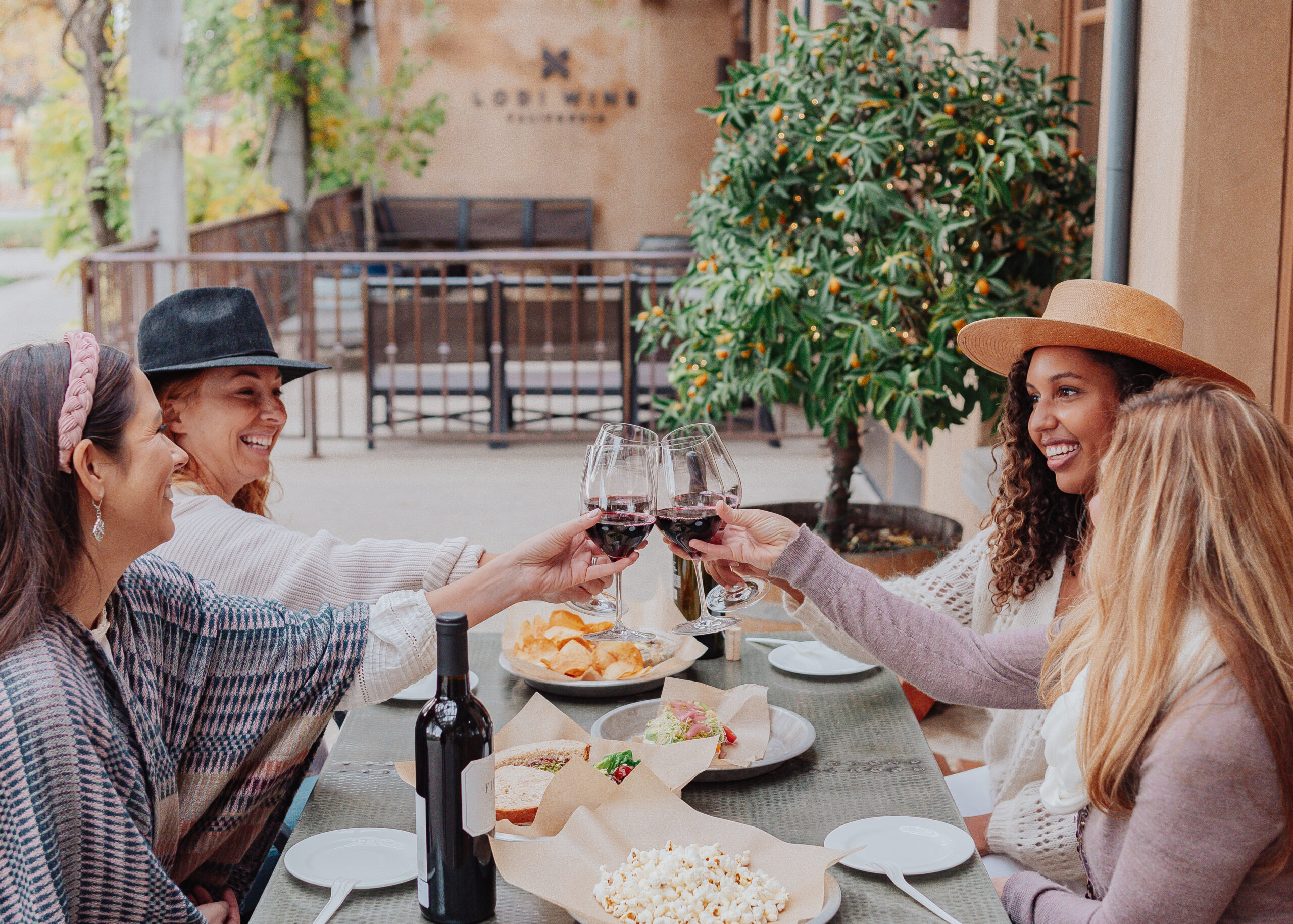 women drinking wine and eating food