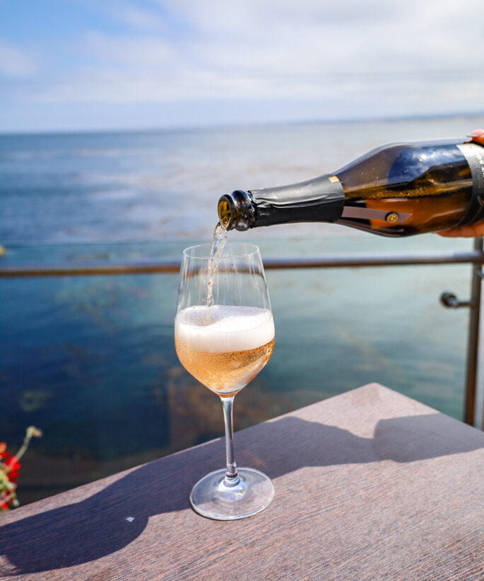 california sparkling wine being poured with coast in the background